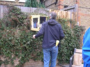 Man looks for a book in a cupboard on the wall in Van Gogh Walk