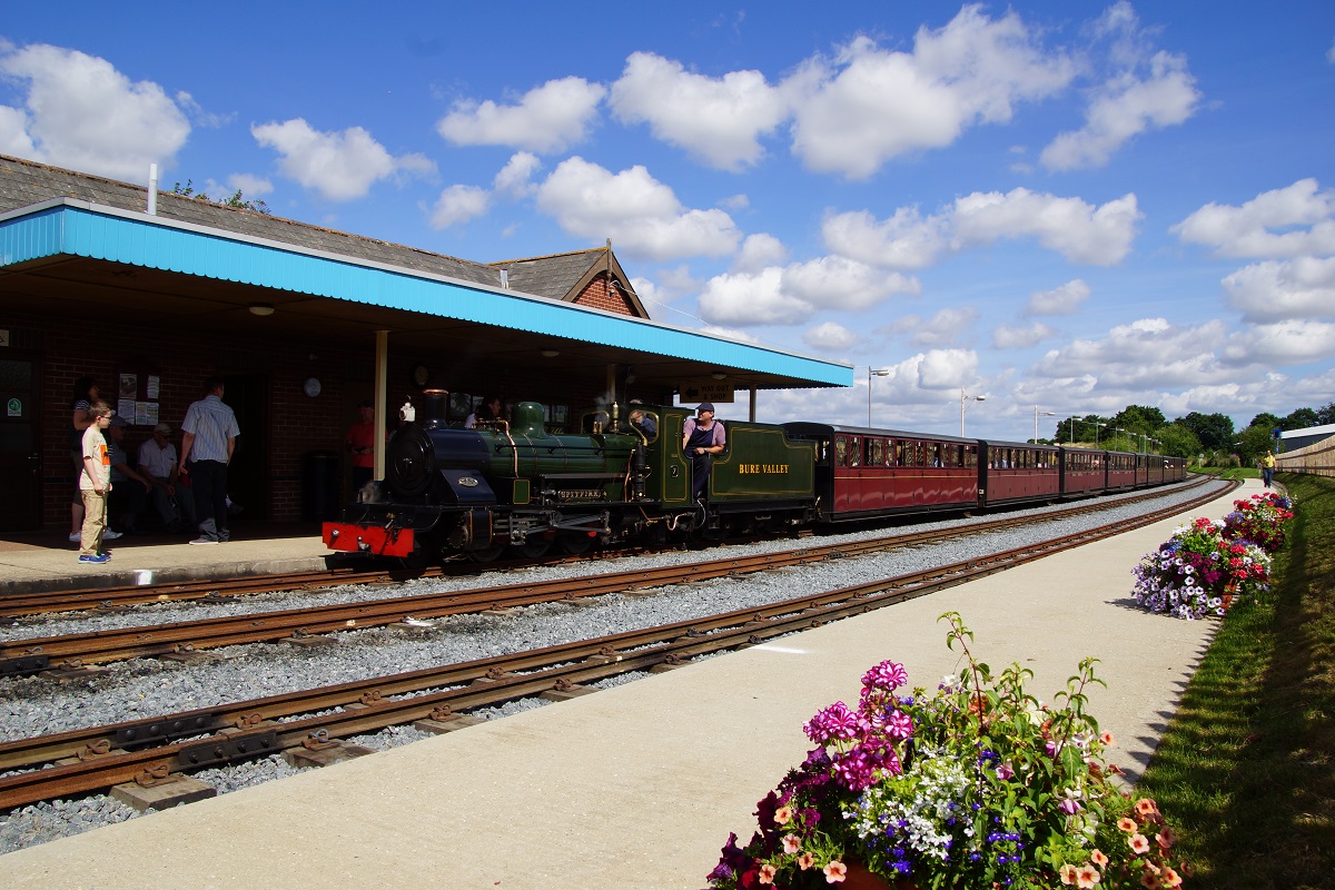 Railway station and steam train with passengers around © bvrw